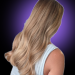 Rear view of long, elegant wavy hair featuring a seamless blonde balayage with honey and caramel tones.