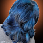 Back view of a layered shag haircut dyed with dimensional ocean blue, cobalt, and dark navy tones.